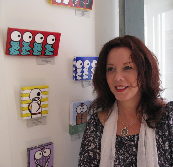 Artist Bethann Shannon next to her paintings at BAC